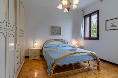 a bedroom with a bed with blue sheets and a chandelier at B&B da Monsignore in Crespano del Grappa