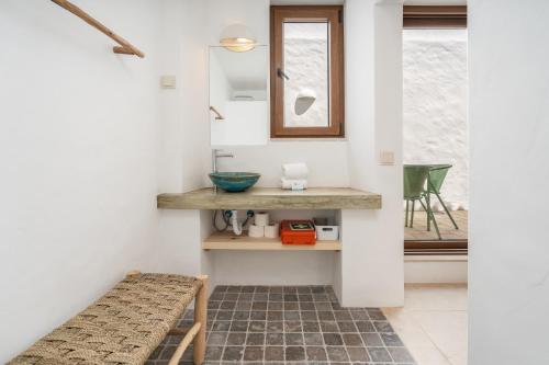 a bathroom with a sink and a bench in a room at Casa Vermelha Alvor in Alvor