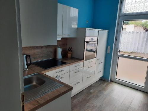 a kitchen with white cabinets and a sink and a window at Ferienhaus Holzminden in Holzminden
