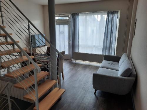 a living room with a couch and a stair case at Ferienhaus Holzminden in Holzminden