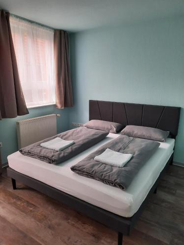 a large bed in a bedroom with a blue wall at Ferienhaus Holzminden in Holzminden