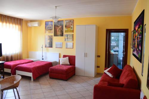 salon z czerwonymi meblami i żółtymi ścianami w obiekcie Casa Dei Puzzle w mieście Matera