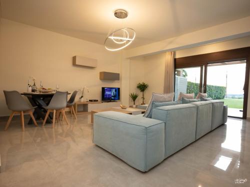 a living room with a couch and a dining room at Palma Villa & Suite With Pool in Nea Kalikratia