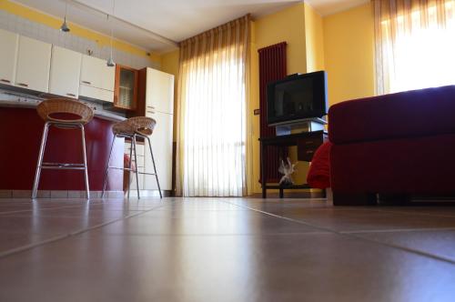 a living room with a couch and a kitchen and a tv at Casa Dei Puzzle in Matera