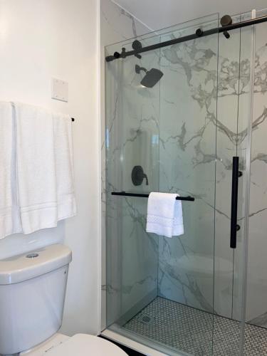 a bathroom with a glass shower with a toilet at Anaheim Maingate Inn in Anaheim
