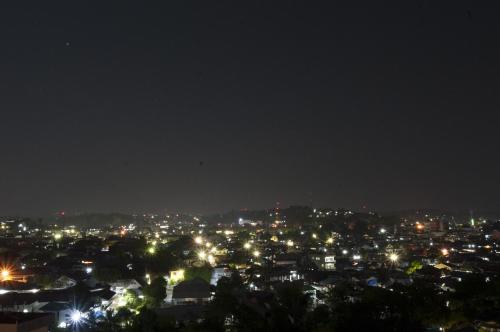 a view of a city at night at Genio Hotel Manado in Manado