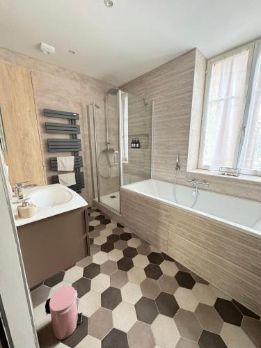 une salle de bain avec une baignoire et un lavabo et une baignoire dans l'établissement Le Stanislas Confort à Colmar - centre ville -, à Colmar