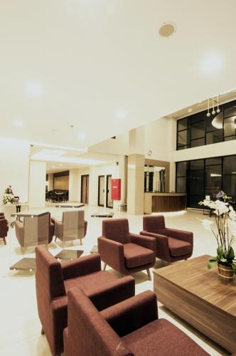 a living room with chairs and a table at Genio Hotel Manado in Manado