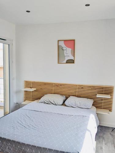 - un lit dans une chambre blanche avec une photo sur le mur dans l'établissement Casa Jenna, à Seillons-Source-dʼArgens