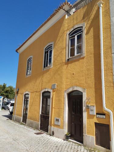 a yellow building on the side of a street at Dom Camilo Alojamento local in Minde