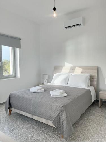 ナウサにあるLinardo's Cycladic Houseの白いベッドルーム(大型ベッド1台、タオル2枚付)