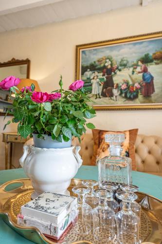 a table with a vase with pink flowers in it at Sir Napier Boutique Guest House in Napier
