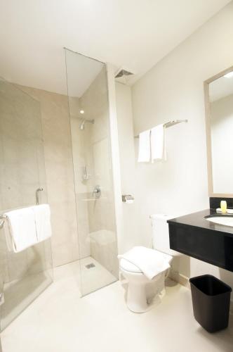 a bathroom with a toilet and a shower at Genio Hotel Manado in Manado