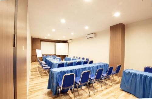 a room with rows of blue tables and chairs at Genio Hotel Manado in Manado