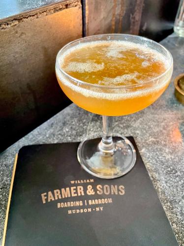 a drink in a martini glass sitting on a bar at Wm. Farmer and Sons in Hudson