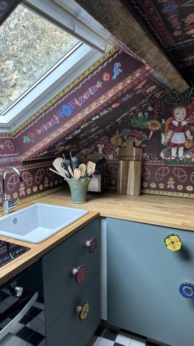 a kitchen with a counter and a sink in a room at AU LIT ON DORT - Logis de Village in Bellême