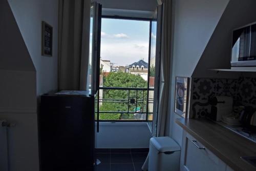 Il comprend une cuisine avec une fenêtre donnant sur un balcon. dans l'établissement Charmant T2 Meaux-gare proche Disney-Paris, à Meaux