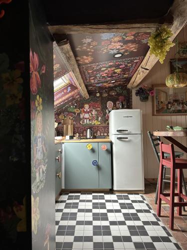 a kitchen with a refrigerator and a tile floor at AU LIT ON DORT - Logis de Village in Bellême