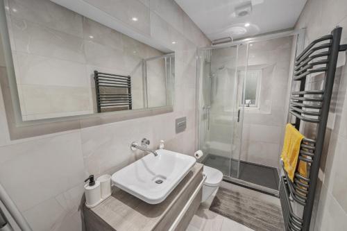 a white bathroom with a sink and a shower at Cosy & Comfortable 2BR in Oban - Walk to Waterfront in Oban