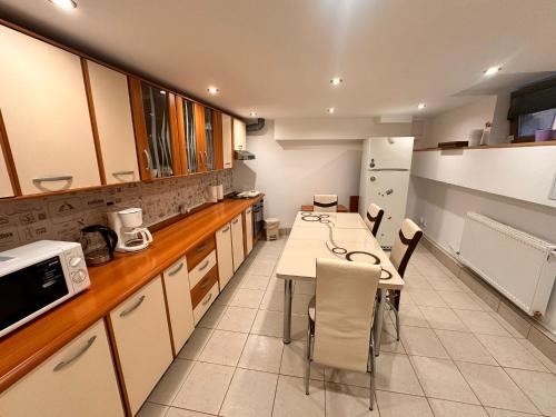 a kitchen with a table and chairs and a refrigerator at La Casa in Sibiu