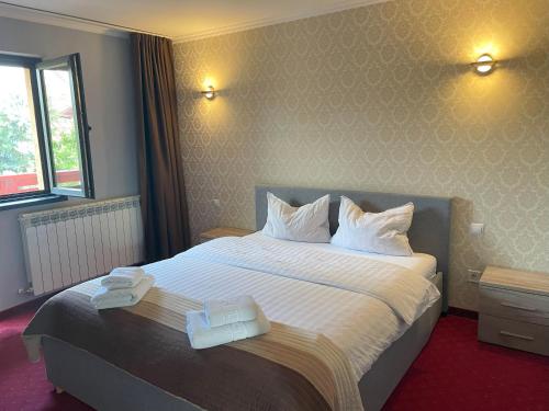 a hotel room with a large bed with towels on it at Casa Sofia in Satu Mare