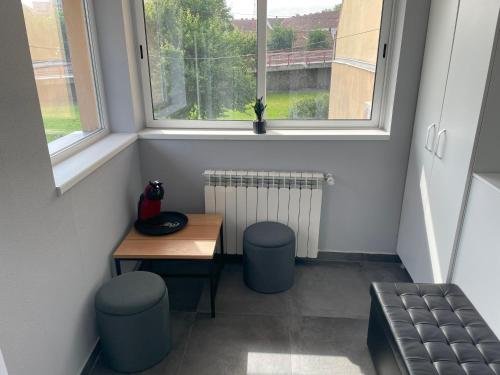 a small room with a table and stools and a window at Casa Sofia in Satu Mare