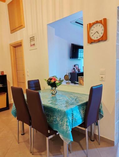 a dining room with a table with chairs and a clock at Traditional house in the centre of Kymi in Kymi
