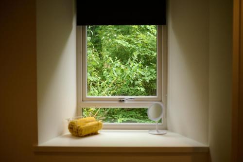 a window in a room with a mirror and a brush at Cosy & Comfortable 2BR in Oban - Walk to Waterfront in Oban