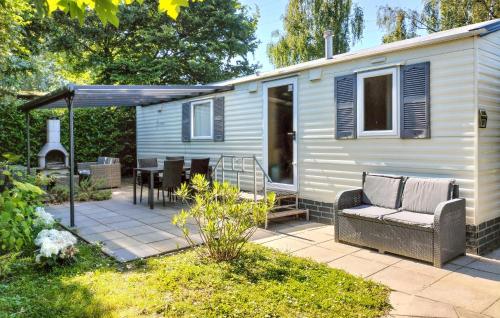 a tiny house with a patio and a grill at 2 Bedroom Lovely Home In Heinkenszand in Heinkensand