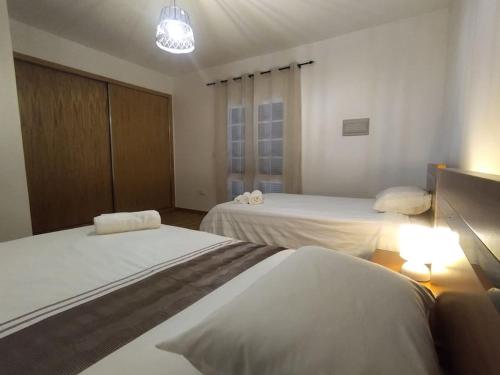 a hotel room with two beds and a light at Casa Neto Jardim in Calheta