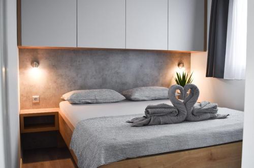 two stuffed swans are sitting on a bed at Luxury mobile home INES in Drage