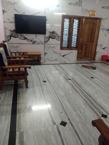 a room with a wooden floor and a flat screen tv at le falls 2 in Kuttālam
