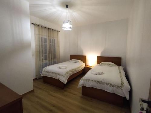 a bedroom with two beds and a light in it at Casa Neto Jardim in Calheta