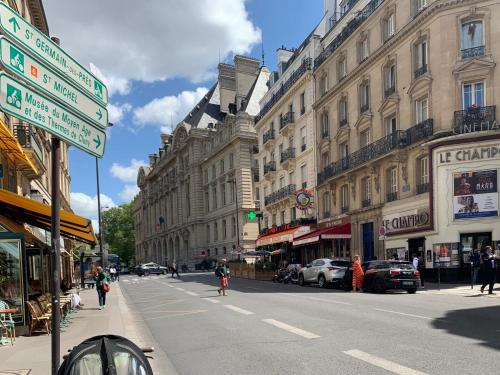 une rue urbaine avec des bâtiments et des gens qui marchent dans la rue dans l'établissement Chaleureux 3 pièces haussmanien au cœur du Quartier Latin, à Paris
