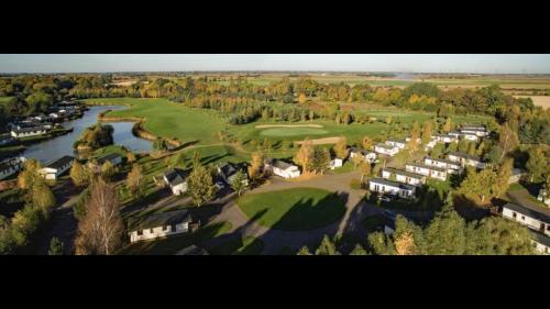 an aerial view of a golf course with a river at Bumblebee Lodge in Tydd Saint Giles