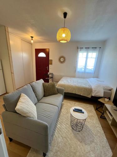 un salon avec un canapé et un lit dans l'établissement Studio Le petit Larros, à Gujan-Mestras