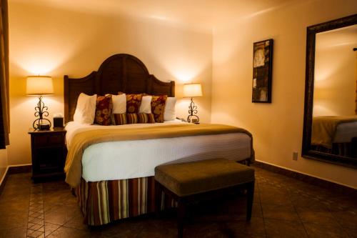 a hotel room with a large bed and a mirror at Los Arboles Hotel in Palm Springs