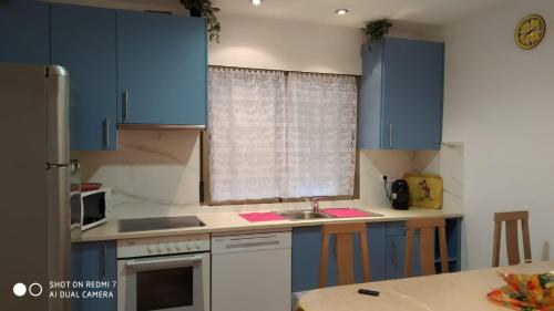 a kitchen with blue cabinets and a sink at Apartamentos La Fuente Ribadeo in Ribadeo