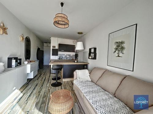 un salon avec un canapé et une cuisine dans l'établissement Studio Alcôve près de la plage avec balcon et WiFi - Quartier Arago - FR-1-331-229, à Les Sables-dʼOlonne