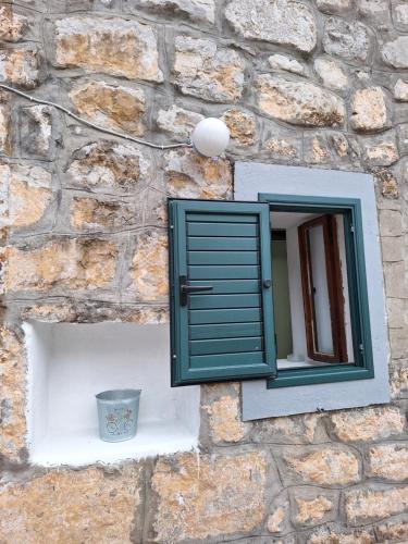 a window on the side of a stone wall at Old stone house Danka in Kotor