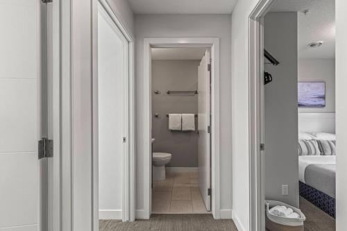 a white bathroom with a toilet and a bed at K202 Hot tub, Pool, MTN view, AC, free parking in Canmore