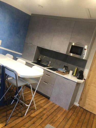 une cuisine avec une table blanche et des chaises dans l'établissement Appartement Caraïbes entre Disney et Paris, à Lagny-sur-Marne