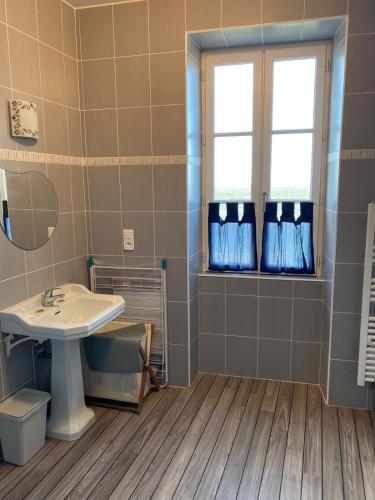 une salle de bain avec un lavabo et une fenêtre dans l'établissement Maison vue sur mer paisible, au Château-dʼOléron