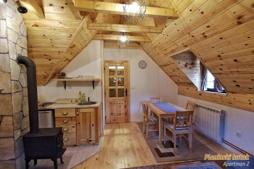 cocina con mesa y techo de madera en PLANINSKI KUTAK Tara - Apartman 2, en Bajina Bašta