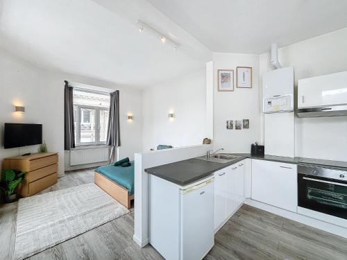 a white kitchen with a sink and a stove at Brussels Grand Place in Brussels
