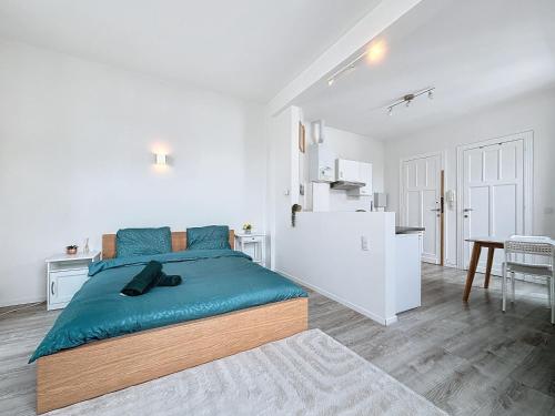 a white bedroom with a large bed and a kitchen at Brussels Grand Place in Brussels