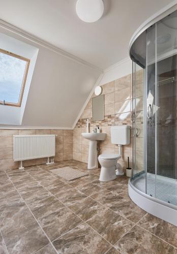 a bathroom with a shower and a toilet and a sink at Silver Cottage in Máriapócs