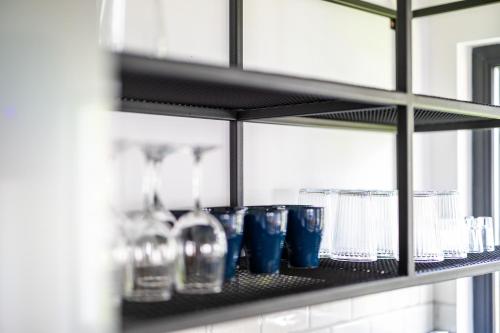 a shelf with glasses and bottles on it at The Bear Chalet with Private Hot Tub in Buşteni