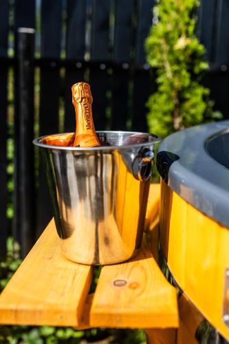 a champagne bottle in a bucket on a table at The Bear Chalet with Private Hot Tub in Buşteni