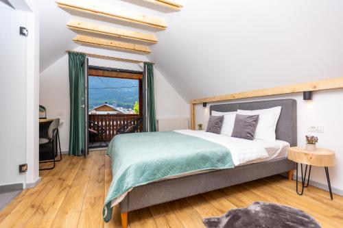 a bedroom with a large bed and a balcony at The Bear Chalet with Private Hot Tub in Buşteni